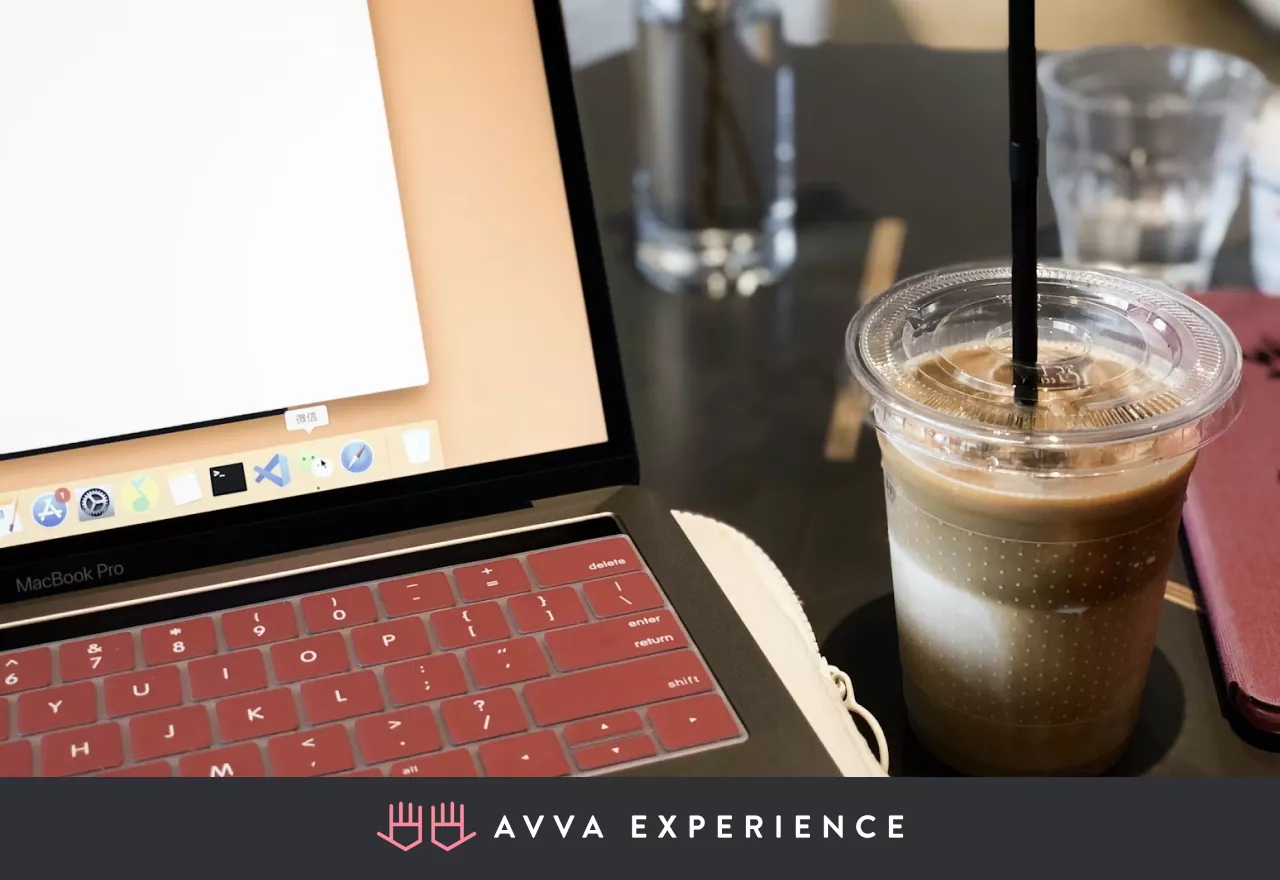 MacBook with a cup of coffee on a workspace