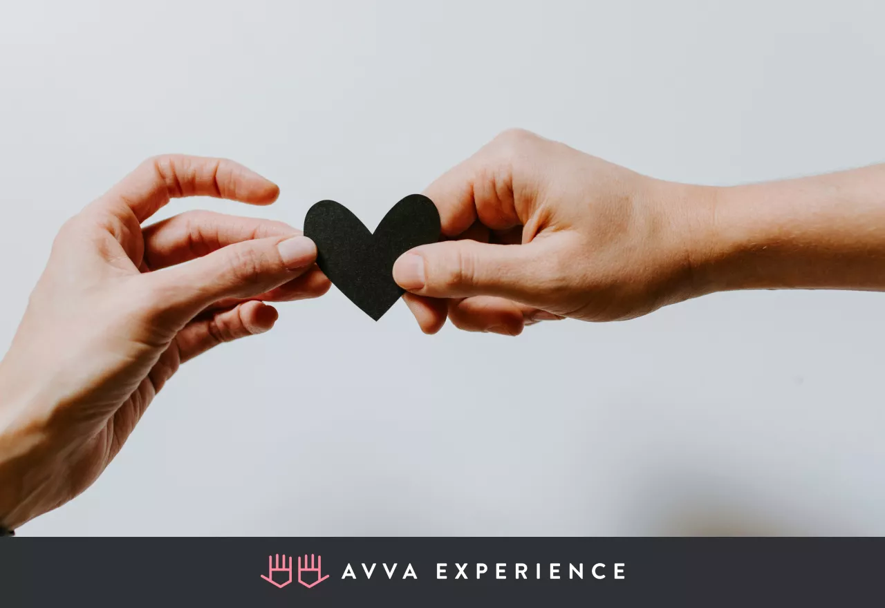 Two people holding a paper heart together, symbolizing client appreciation